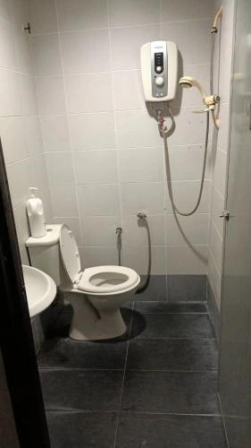 a bathroom with a toilet and a shower in a stall at Hotel Checkedinn in Ipoh
