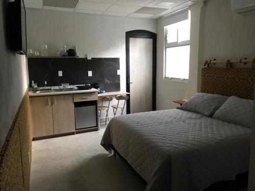 a bedroom with a bed and a kitchen with a sink at Las heliconias 3 moderno loft in Oaxaca City