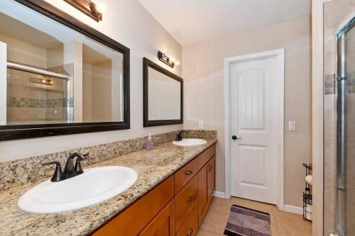 ein Badezimmer mit zwei Waschbecken und einem großen Spiegel in der Unterkunft Timber lodge Retreat w/Game room in Sugarloaf