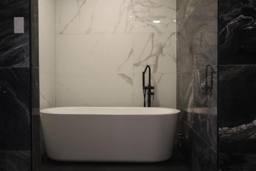 帕拉馬里博的住宿－Empire Villa Paramaribo Noord 1，黑白浴室设有白色浴缸。