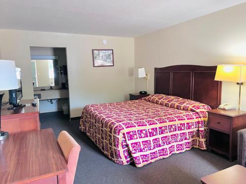 ein Hotelzimmer mit einem Bett und einem Tisch in der Unterkunft Ashley inn in Crossett