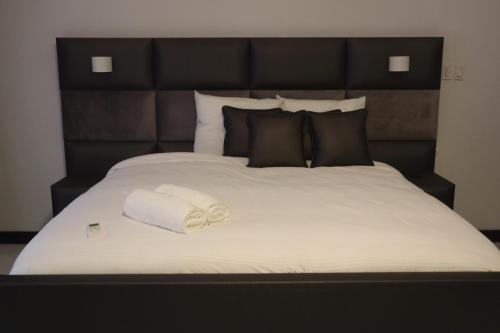 a large bed with a roll of towels on it at Empire Villa Paramaribo Noord 1 in Paramaribo