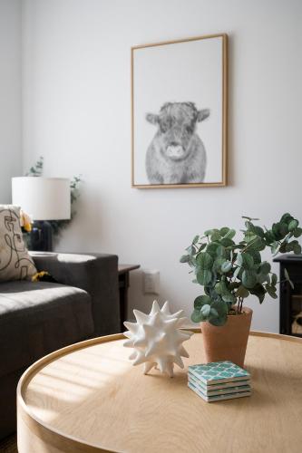 a living room with a table with a picture of a sheep at The Darcie House - cozy, pet-friendly home in PEC in Picton