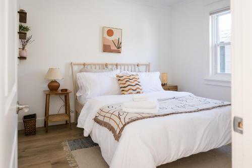 - une chambre blanche avec un grand lit et des draps blancs dans l'établissement The Darcie House - cozy, pet-friendly home in PEC, à Picton