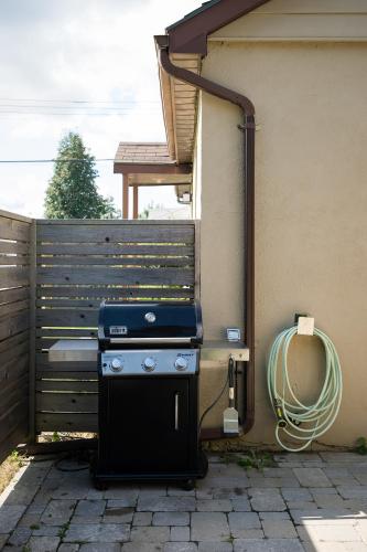 a grill sitting on the side of a house at The Darcie House - cozy, pet-friendly home in PEC in Picton