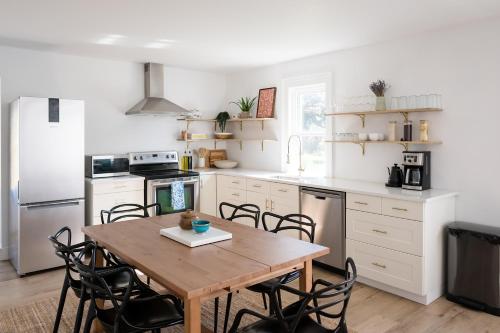 - une cuisine avec une table et des chaises en bois dans l'établissement The Darcie House - cozy, pet-friendly home in PEC, à Picton