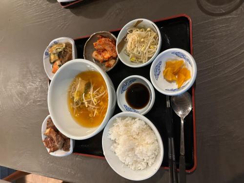 um tabuleiro de comida com tigelas de comida e arroz em Hotel Kojan em Osaka