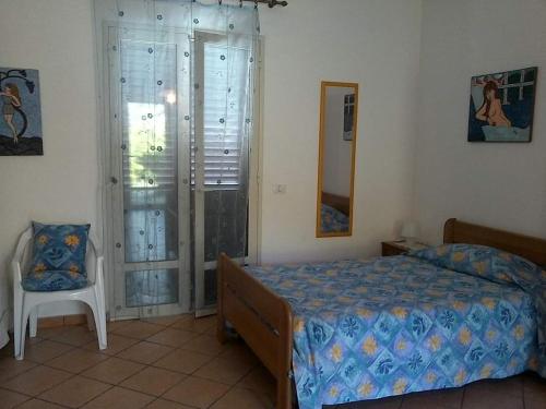 - une chambre avec un lit, une chaise et un miroir dans l'établissement paradisoTaorminaEtna, à Piedimonte Etneo