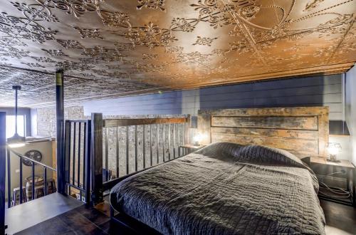 sypialnia z łóżkiem i kasetonowym sufitem w obiekcie Lincolns Loft Speakeasy Suite w mieście Lincoln