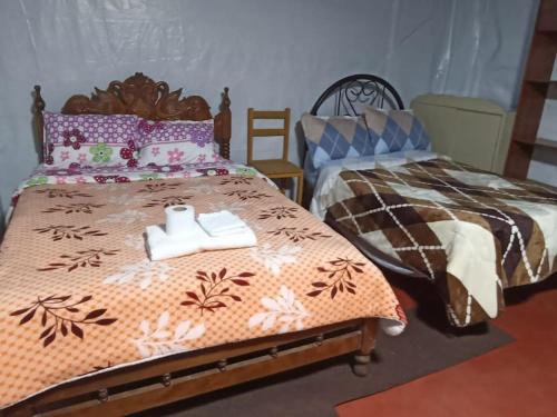 a bedroom with two beds with towels on them at Posada Shumac Ñahui baño privado y ducha caliente in Huaraz