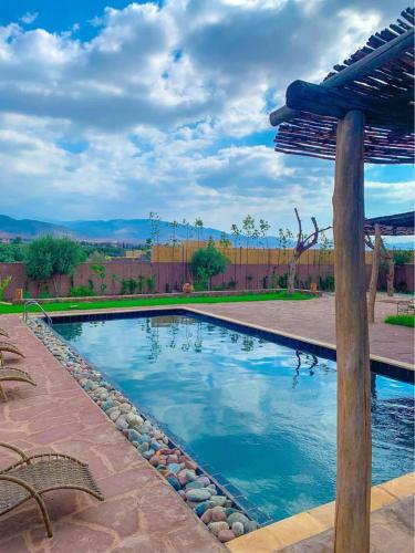 a large swimming pool with a pergola on a patio at Bienvenue à la Villa Luxe de 3 Suites pour Location Journée ! in Marrakesh