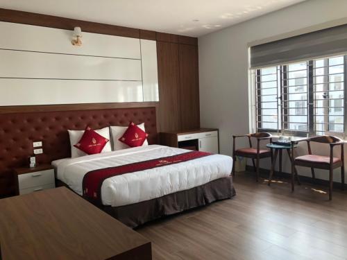 a hotel room with a bed and a table and chairs at Bình Long II Hotel in Lai Châu