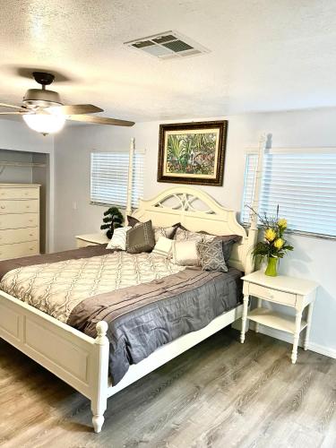 - une chambre avec un grand lit et une table fleurie dans l'établissement A Cozy Space Coast Retreat, à Titusville