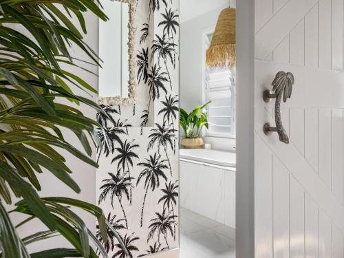 a bathroom with a palm tree wallpaper at Kia Orana Island Home with Pool in Casuarina