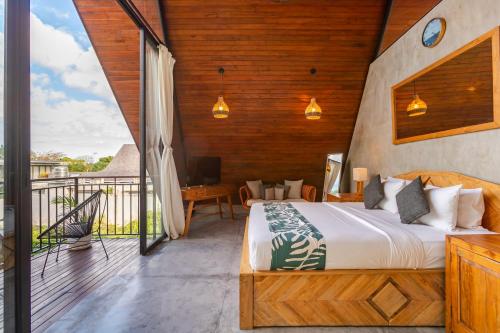 a bedroom with a bed and a balcony at Modern 2 BR Villa Indra by Azure, in the Lap of Nature in Munggu