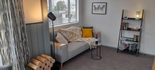 a living room with a couch and a window at River and Ridge Getaway in Turangi