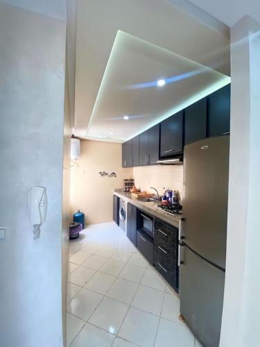 una cucina con armadi neri e frigorifero in acciaio inossidabile di Appartement familial 1 - Cité essalam ad Agadir