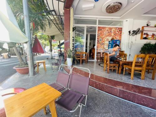 Un uomo seduto a un tavolo fuori da un ristorante di Ngọc Trung Hotel a Quy Nhon