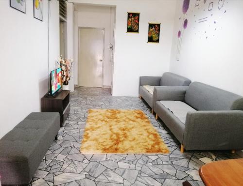 una sala de estar con 2 sofás y una alfombra en Destiny Homestay, en Sungai Petani