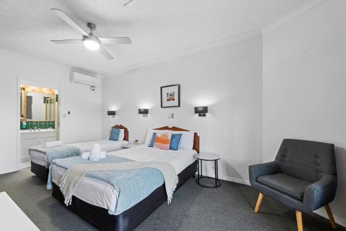 a bedroom with a bed and a chair at Airport Clayfield Motel in Brisbane