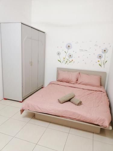 a bedroom with a pink bed and a cabinet at Destiny Homestay in Sungai Petani