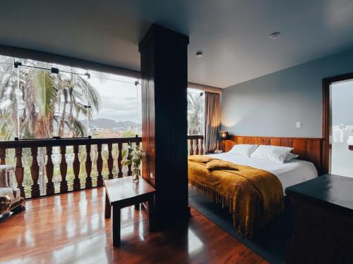 a bedroom with a bed and a large window at Hotel Victoria in Cuenca