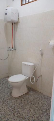 a bathroom with a toilet in a room at FARILA LODGE in Kelimutu
