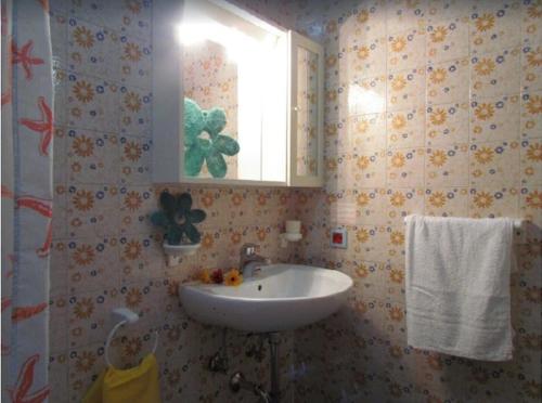 uma casa de banho com um lavatório e uma janela em Seafront building in a great location - Beahost em Bibione