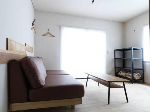 a living room with a couch and a coffee table at 富士山ビューの貸切宿 屋根付きウッドデッキでbbq可 浅間神社近く in Fujiyoshida