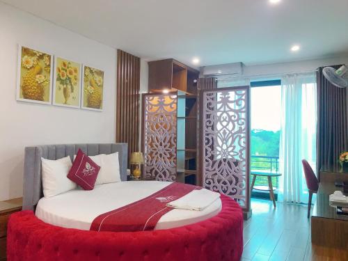 ein Schlafzimmer mit einem Bett mit einer roten Ottomane in der Unterkunft Rosy Hotel Dương Nội in Hà Ðông