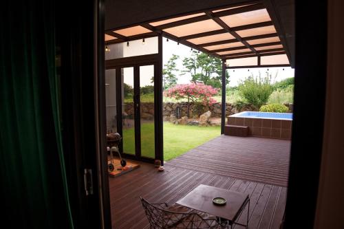 an open door to a deck with a swimming pool at Hyeopjae MoonBeam in Jeju