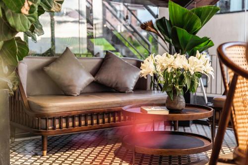 a couch on a balcony with a table and flowers at Miền Sương Khói - Home & Café in Khu Chi Lăng