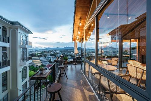 a balcony with tables and chairs and a view of the city at Miền Sương Khói - Home & Café in Khu Chi Lăng