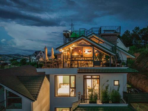 a house with a balcony with lights on it at Miền Sương Khói - Home & Café in Khu Chi Lăng