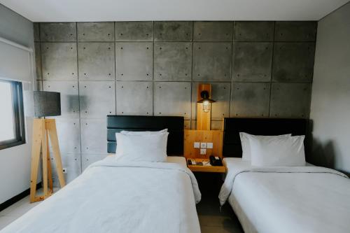 two beds sitting next to each other in a room at Ayaartta Hotel Malioboro in Yogyakarta