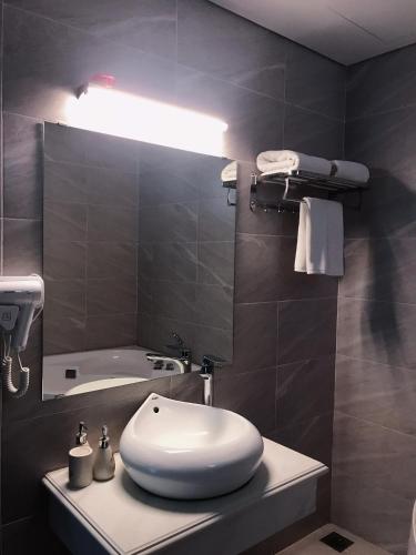 a bathroom with a white sink and a mirror at Rosy Hotel Dương Nội in Hà Ðông