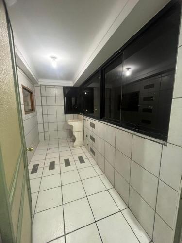 een wit betegelde badkamer met een wastafel en een toilet bij Temporary departament in Cuzco