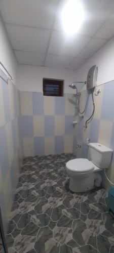 a bathroom with a toilet and a tiled floor at Chadini Holiday Home in Gawarammana