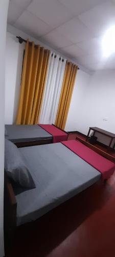a bedroom with two beds and a window at Chadini Holiday Home in Gawarammana