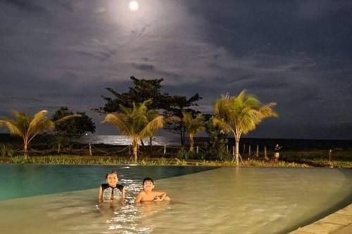 two people swimming in a swimming pool at night at 17 Riada Villa in San Juan