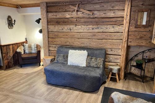 - un salon avec une chaise et un mur en bois dans l'établissement La Dorbluche apartment 4-6 person, à Longefoy
