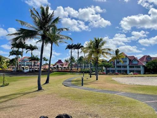 a park with palm trees in front of a resort at Studio dans un magnifique complexe de vacances a ST luce in Sainte-Luce