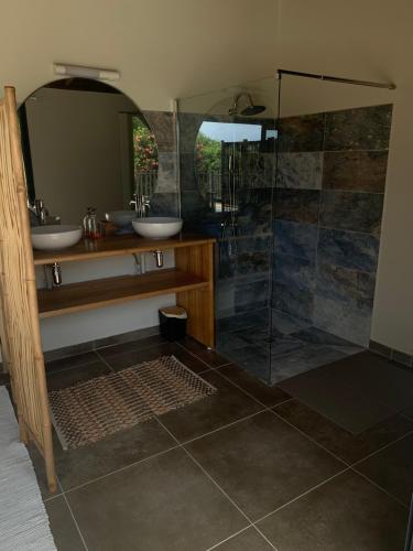 ein Badezimmer mit zwei Waschbecken und einer Glasdusche in der Unterkunft Héritage créole 4 - Mazurka in Sainte-Luce