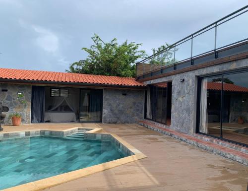 une terrasse avec une piscine et une maison dans l'établissement Héritage créole 4 - Mazurka, à Sainte-Luce