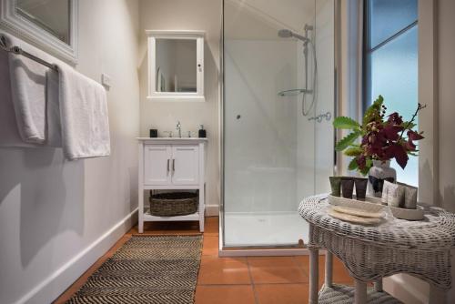 a bathroom with a shower and a table and a sink at Illoura in Hepburn Springs