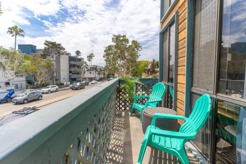 a balcony with green chairs and a city street at Pineapple Paradise - Mission Beach - Stunning in San Diego