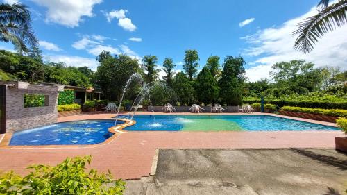 a swimming pool with a fountain in a yard at Centro Vacacional Campo Alegre in Guamal