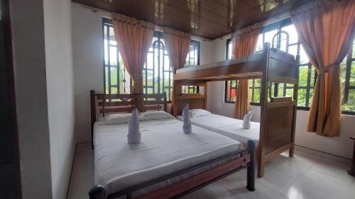 1 dormitorio con 2 camas en una habitación con ventanas en Centro Vacacional Campo Alegre, en Guamal