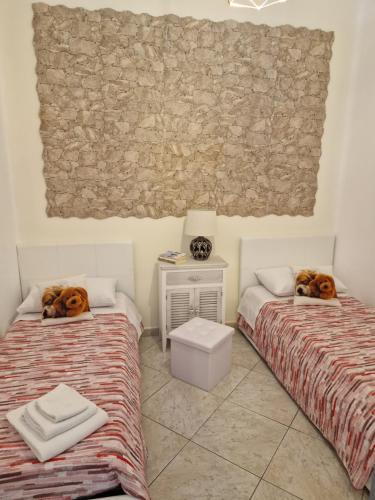 two beds in a room with two dogs laying on them at Residenza Giuseppina in Siracusa