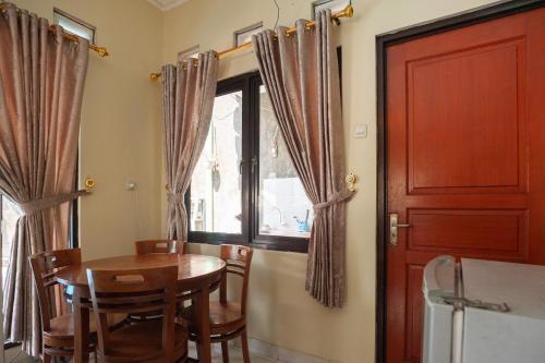 a dining room with a table and chairs and a window at Urbanview Resort Syariah Khansa Cisarua Puncak by RedDoorz in Tagalbato